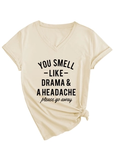 Detail eines beige T-Shirts mit V-Ausschnitt, You Smell Like Drama Spruch und Knoten