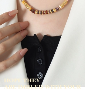 Close-up of bohemian beaded necklace with mixed colored stones and gold spacers on a model