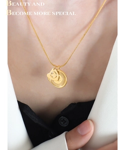 Détail d'un collier chaîne serpent dorée à plusieurs rangs avec pendentif étoile et lune