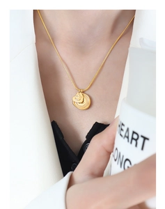 Détail du collier plaqué or 18 carats avec pendentifs cœur et soleil sur un mannequin