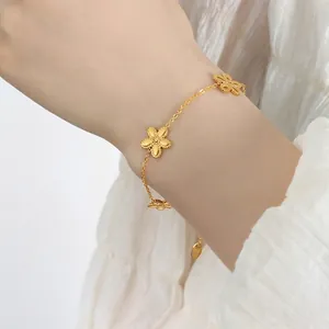 Vergoldetes Gänseblümchen-Armband mit mattierten Blütenanhängern am eleganten Handgelenk