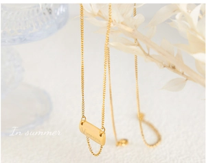 Close-up of gold square pendant with English engraving on 18K gold plated titanium chain