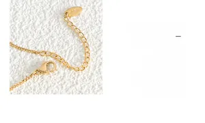 Detail of 18K gold plated chain featuring a lobster clasp and extension links with K18 stamp