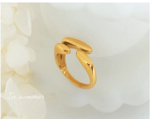 Détail macro d'une bague ouverte dorée asymétrique au design fluide minimaliste