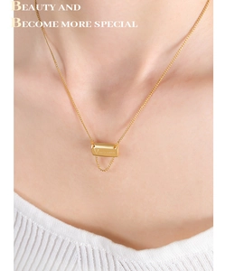 Close-up of a square letter V pendant with tassel chain on a gold-plated necklace