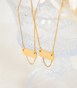 Macro view of a 18K gold-plated titanium steel rectangular pendant with V LOSAVIFFN engraving