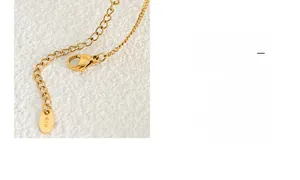 Close-up of 18K gold-plated lobster clasp and engraved K18 tag on square pendant necklace