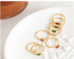 Detailed macro view of colorful gemstones set in thin gold-plated minimalist bands