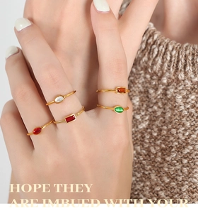 Detail of vintage stackable gold-plated rings with colorful gemstones on a knit background