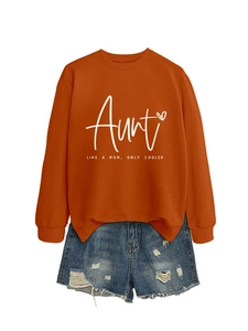 Flat lay of an orange 'Aunt Like A Mom' sweatshirt paired with distressed denim shorts