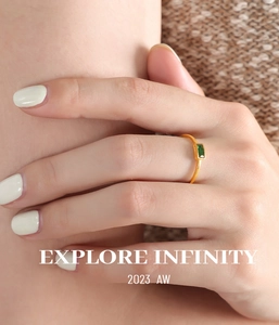 Close-up of minimalist thin gold ring featuring a rectangular green zircon stone