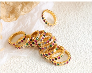 Macro view of gold plated titanium rings featuring colorful pavé rainbow crystals