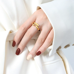 Bague ouverte géométrique irrégulière en finition dorée sur le doigt d'un modèle