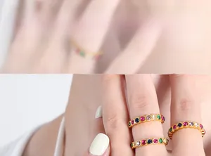 Detailed close-up of gold-plated rings with multi-colored crystals in a channel setting
