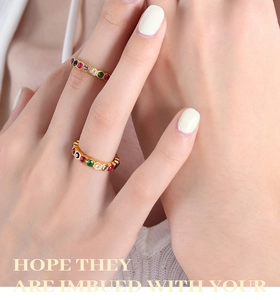 Close-up of dual gold-plated titanium rings set with vibrant multi-color crystal zircons