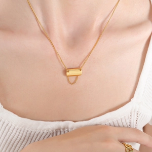 Gold rectangular letter pendant necklace with tassel detail in 18K gold plated steel