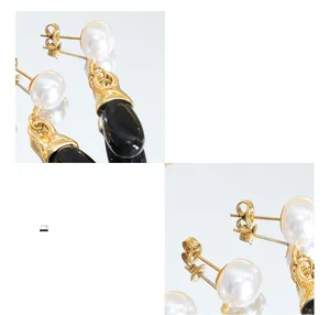 Detail of elegant earrings with white faux pearls and black drop charms in 18K gold plating