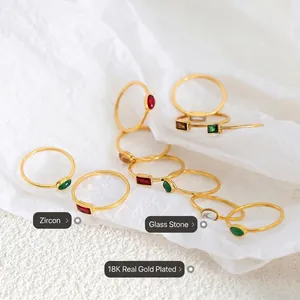 18K gold plated thin rings with zircon and glass stones on white textured paper