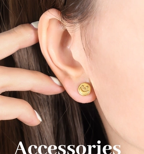 Close-up of a gold-plated titanium steel earring with embossed star and moon pattern