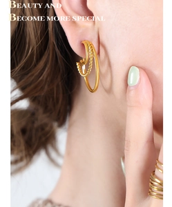 Close-up of 18K gold plated C-shaped hoop earrings with smooth and twisted texture