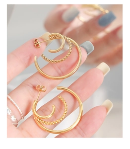 Close-up of triple-layered 18K gold-plated C-shaped earrings with twisted rope texture