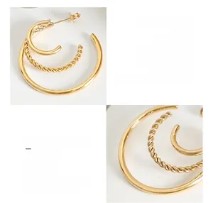 Detailed close-up of C-shaped titanium steel earrings with 18K gold plated texture