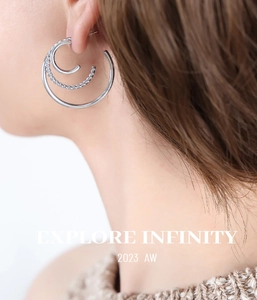 Close-up of triple-layered silver hoop earrings with rope texture design on model