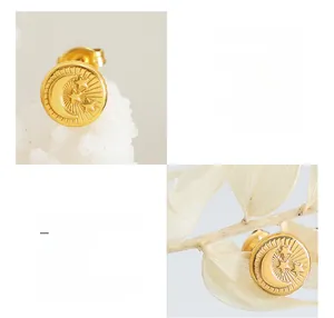 Close-up of titanium steel gold-plated earrings with embossed moon and star patterns