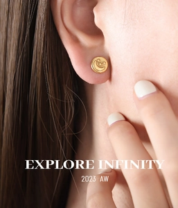 Close-up of gold titanium steel earring with embossed star and moon design