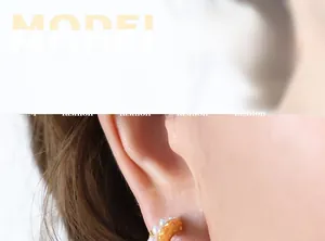 Close-up of elegant C-shaped gold pearl earrings on model showing vintage texture