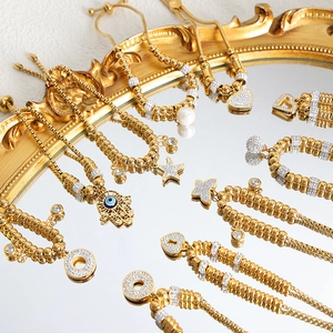 18K gold-plated geometric bracelet stack with Hamsa hand, heart, and star charms