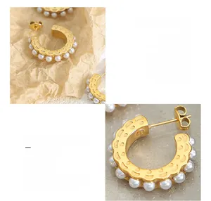 Close-up of C-shaped titanium steel earrings with 18K gold plating and pearl inlay
