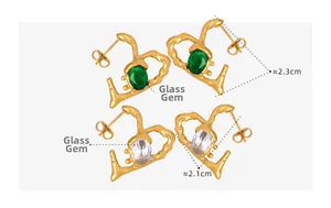 Detail showing irregular gold heart earrings with emerald green and clear glass rhinestones