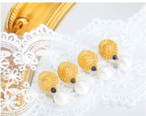 Detail of vintage 18K gold plated earrings with blue gemstone and round white pearls