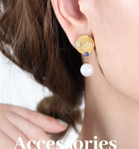 Detailed close-up of retro 18K gold-plated earring with blue stone and pearl pendant