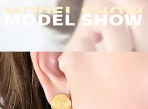Close-up of a model wearing a vintage French gold-plated coin stud earring with embossed portrait