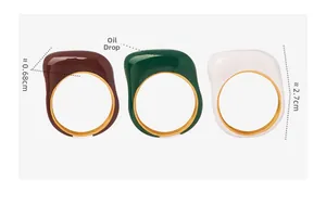 Détail de bagues en émail marron, vert et blanc avec intérieur doré poli