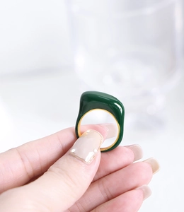 Gros plan sur la bague en émail vert émeraude avec anneau interne en métal doré