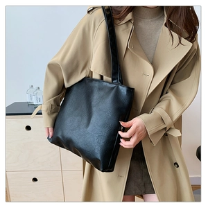 Große schwarze Tote Bag im minimalistischen Lederstil getragen von einem Model