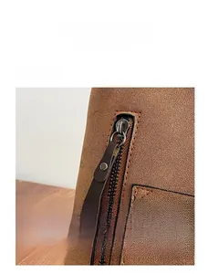 Macro shot of smooth metal zipper and leather pull on a brown faux suede handbag detail
