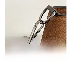 Macro detail of the durable silver metal clasp and buckle on the brown suede handbag