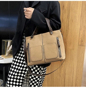 Detail of khaki frosted faux leather handbag with dual front zippers and adjustable strap