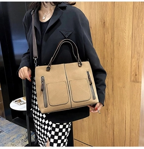 Detail view of khaki matte leather tote bag with dual front zipper pockets and shoulder strap