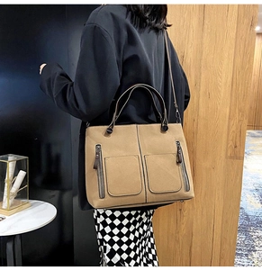 Khaki retro tote bag with dual front pockets shown in a modern lifestyle setting