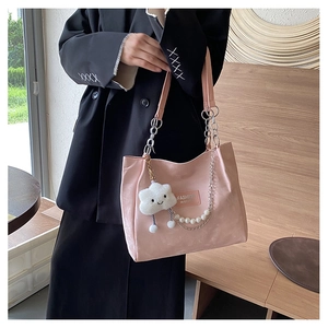 Détail du sac cabas rose clair avec chaîne en perles, charme nuage et maillons métalliques
