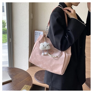 Détail du sac cabas en cuir PU rose avec breloque nuage en peluche et chaîne de perles