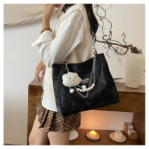 Détail du sac cabas en PU noir avec bandoulière chaîne et breloque nuage en peluche