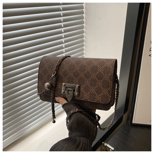 Detail of vintage brown patterned shoulder bag with gold chain strap and metal clasp