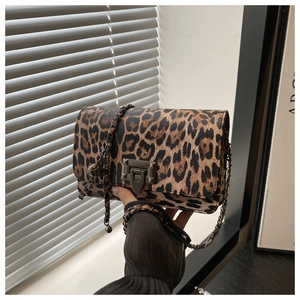 Detail of leopard print shoulder bag featuring metal chain strap and vintage clasp closure