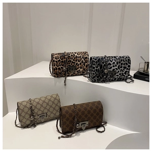 Collection of leopard and monogram chain shoulder bags on white display steps